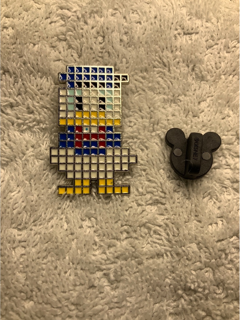 Disney pin featuring Donald Duck in a colorful pixel-style grid design.